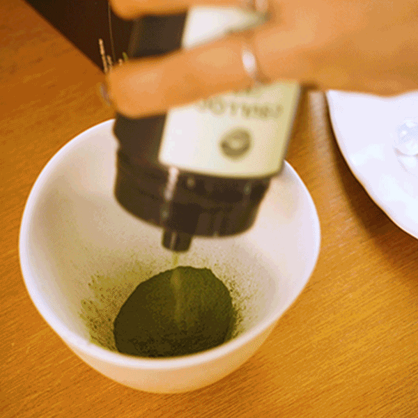 Osulloc Matcah Mania Bundle featuring a hand dispensing vibrant green matcha powder into a bowl.