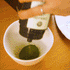 Osulloc Matcah Mania Bundle featuring a hand dispensing vibrant green matcha powder into a bowl.