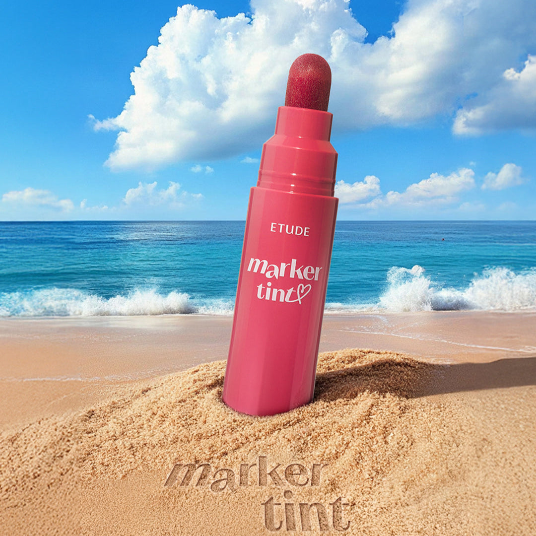 ETUDE marker tint on a sandy beach with ocean and blue sky in the background