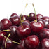 Fresh, glistening cherries piled together, showcasing their vibrant color and luscious texture for an appetizing look.