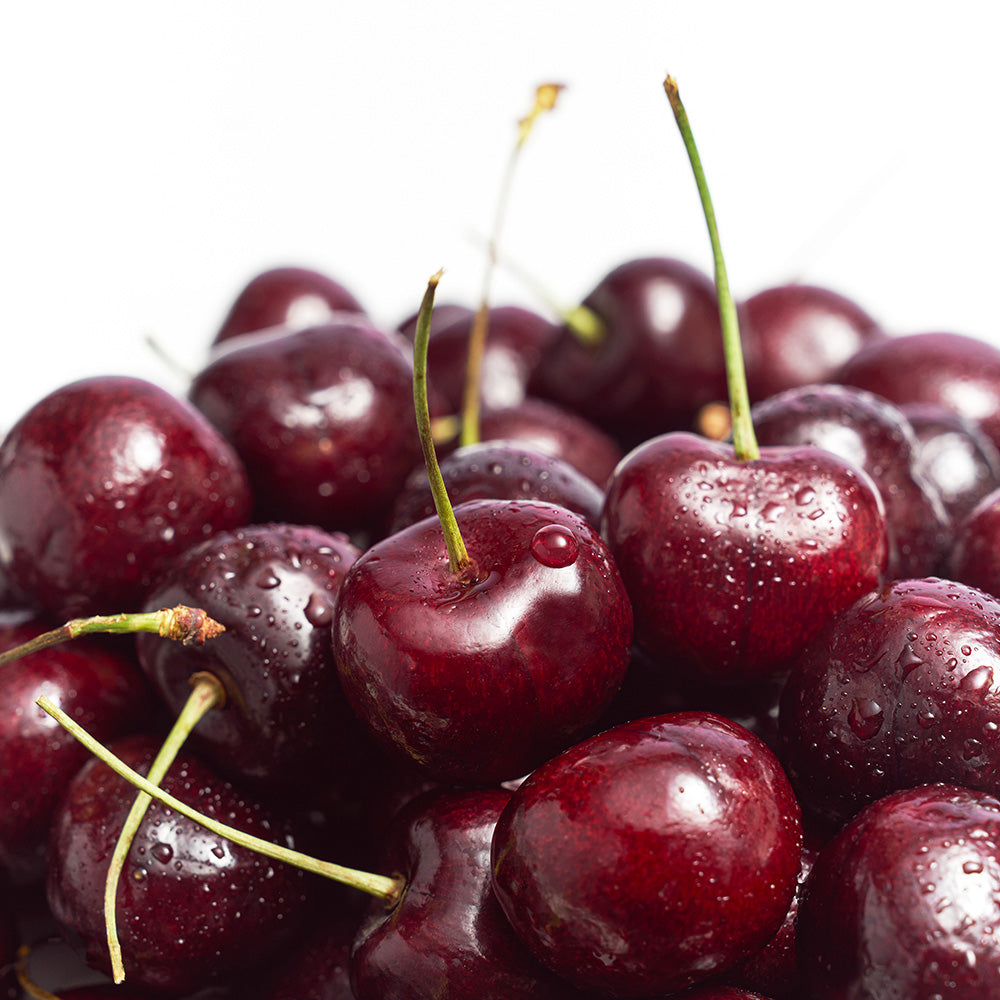 Fresh, glistening cherries piled together, showcasing their vibrant color and luscious texture for an appetizing look.